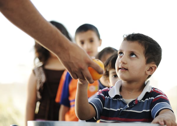 Hungry children in refugee camp, distribution of humanitarian food