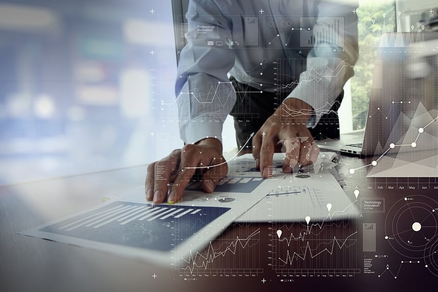 close up of businessman hand working on laptop computer with financial business graph information diagram on wooden desk as concept